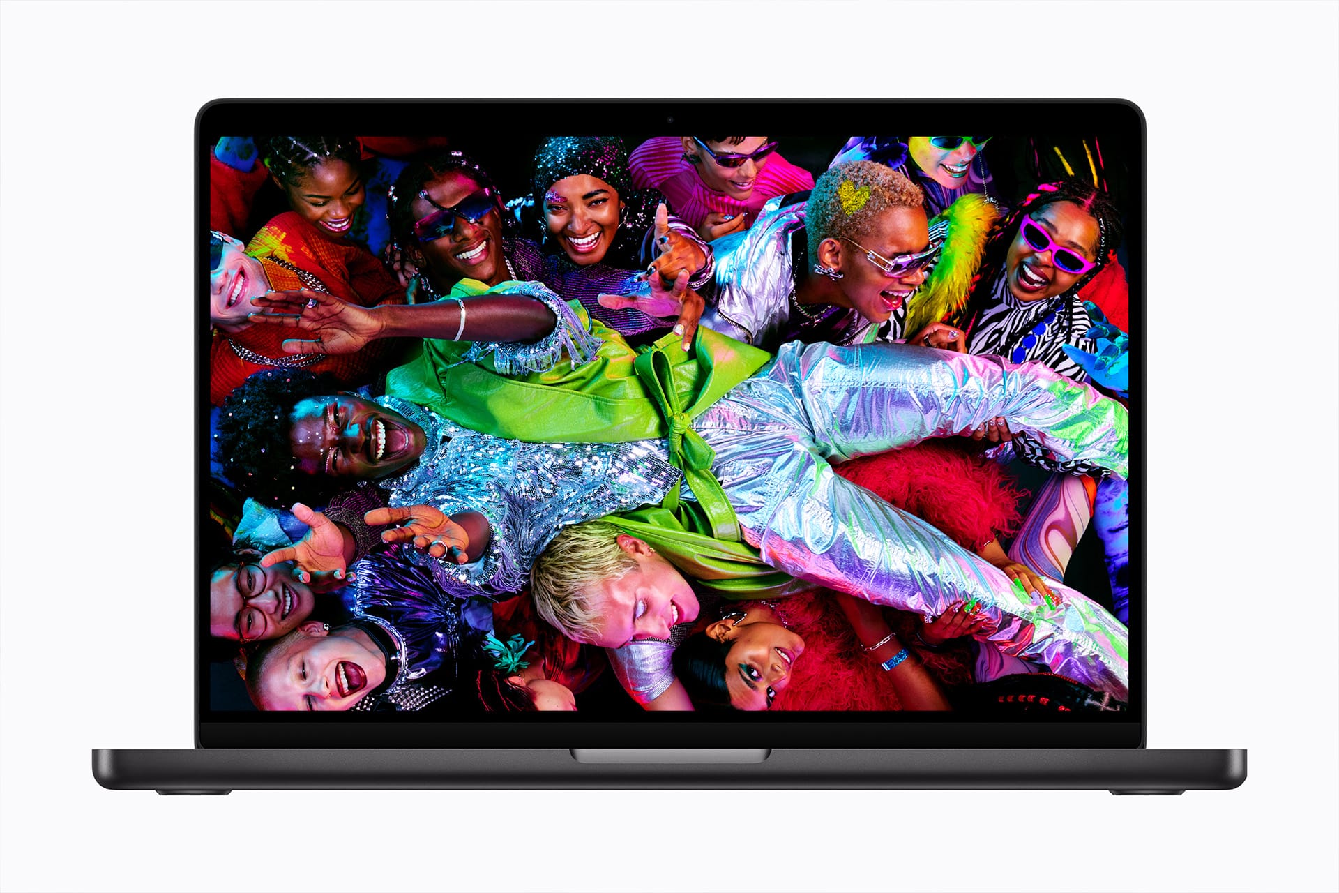 A laptop with a colorful, vibrant image on its screen showing a lively group of people dressed in bright, sparkling outfits, celebrating and smiling closely together.