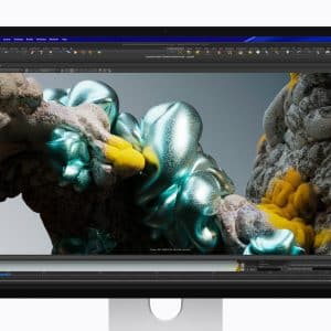 A computer monitor displays a 3D modeling program with an abstract, organic structure featuring shiny teal and yellow textured surfaces rendered on the screen.