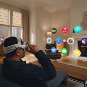 A person wearing a VR headset sits on a couch in a living room, interacting with floating digital app icons using Vision Pro Gestures, seamlessly blending virtual elements with the real home environment.