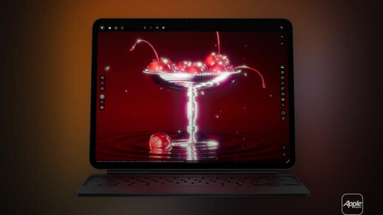 A tablet with a keyboard displays a digital image of cherries in a glass dessert dish against a deep red background. The Apple logo appears in the bottom right corner, and editing tools are visible on the iPad XDR monitor screen.