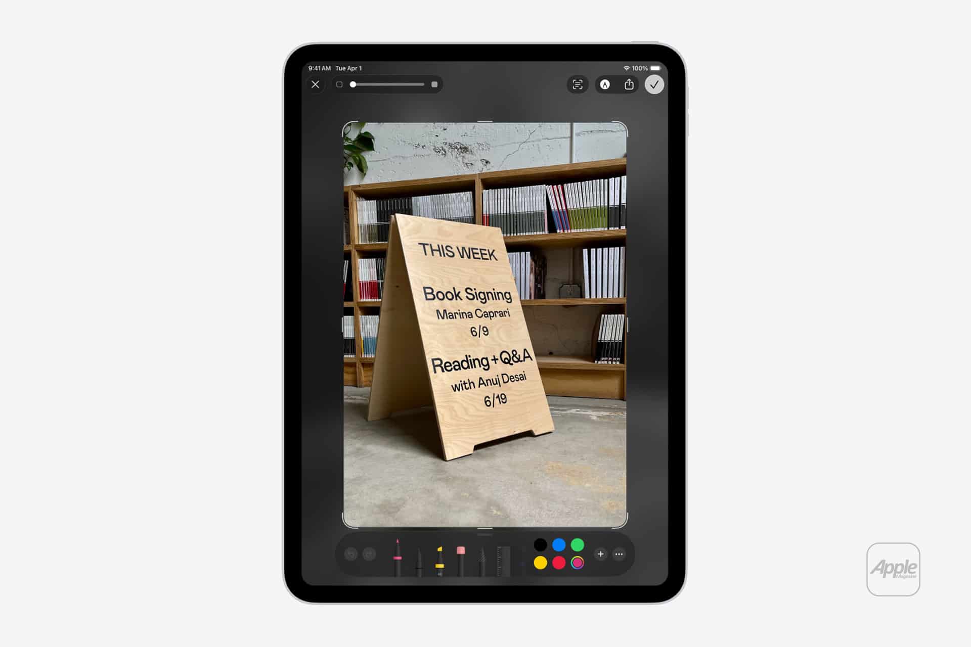 An iPad running iPadOS displays a photo being edited of a wooden sign listing upcoming bookstore events: a book signing with Marina Caprini and a reading and Q&A with Anil Desai, both on 6/19.