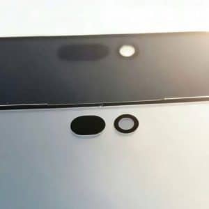 Close-up of two smartphone screens, one black and one white, each showing front camera cutouts and sensor holes, possibly hinting at a Dynamic Island design. Bright light is visible in the background in these first images from an iPhone 18 leak.