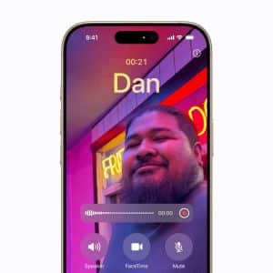 A smartphone screen shows a FaceTime call with a man smiling in front of neon lights, the name “Dan” at the top, call controls at the bottom, and an iPhone Call Recording indicator visible on the display.