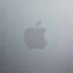 The image shows a silver metallic surface with the Apple logo in the center, which is a stylized silhouette of an apple—iconic to every MacBook Neo—with a bite taken out on the right side and a small leaf on top.