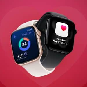 Two smartwatches overlap on a red heart background; one displays a sleep score of 84, while the other shows a heart icon with a "Possible Hypertension" alert—highlighting Apple Watch recovery features. The Apple logo appears in the lower right corner.