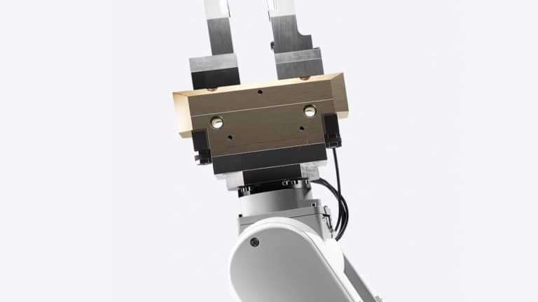 A close-up view of a robotic arm with a metallic gripper, featuring two parallel jaws and exposed mechanical components, similar to those used in the Apple recycling program, set against a plain white background.