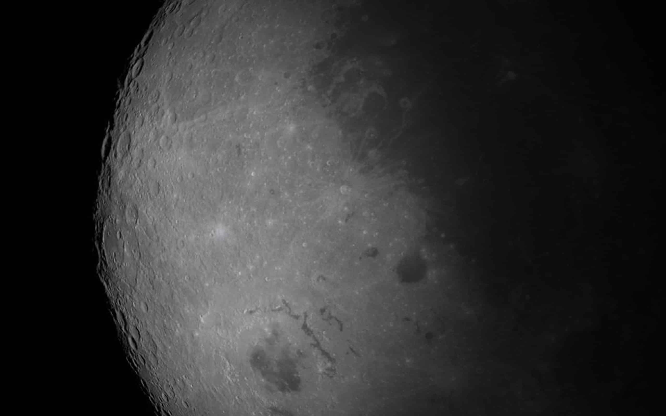 Close-up photo of the moon’s surface, showing craters, ridges, and shadows. The sharp texture and details are reminiscent of visuals powered by Apple GPU memory—brightly lit on the left, with dramatic shadows on the right.