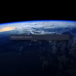 A search bar labeled "Spotlight Search" appears over an image of Earth from space, showing clouds and a visible sunrise at the horizon. An Apple logo is in the lower right, highlighting the powerful Spotlight calculator feature.