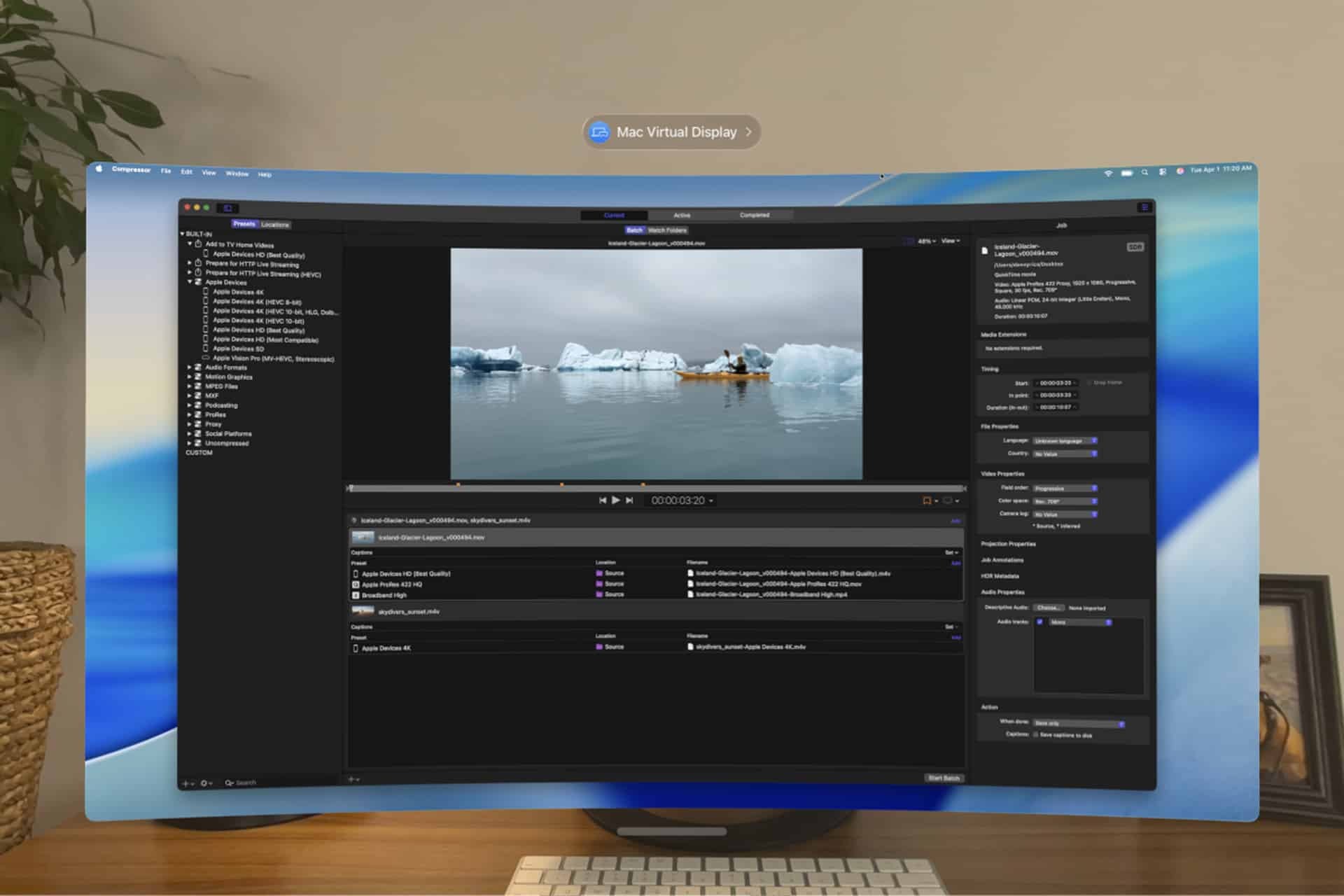 A curved computer monitor, serving as a Vision Pro Mac Display, shows video editing software with a boat near icebergs. The workspace includes panels for files, settings, and export options. A basket is visible on the left.