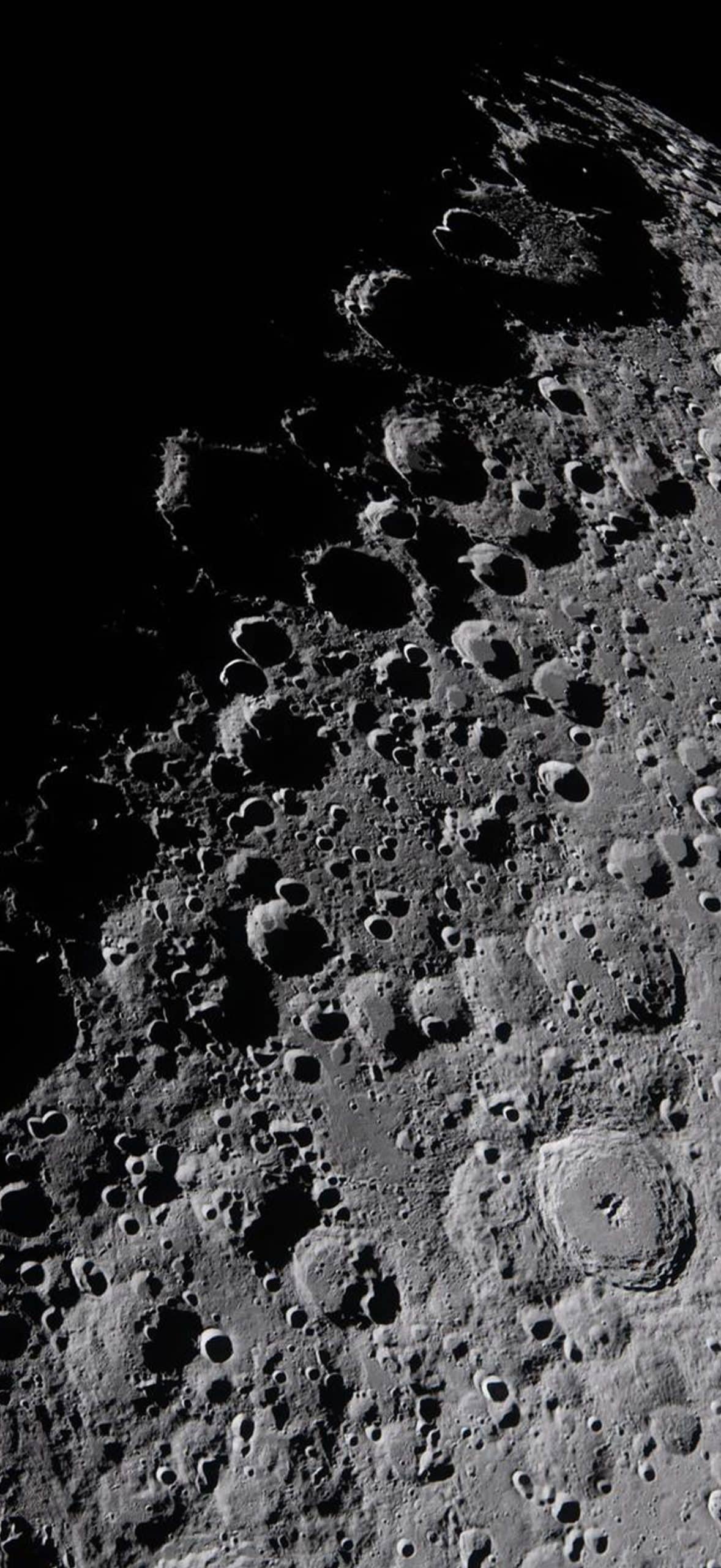 Detailed close-up image of the moon’s surface, showcasing craters and rugged terrain under stark lighting—rendered with clarity akin to Apple GPU memory performance—set against a deep black space background.