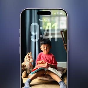 A smartphone screen shows a lock screen with a young child reading beside a stuffed horse. The time is 9:41, the date Tuesday, April 1, and the Apple logo in the corner—an everyday moment captured before iphone data recovery is needed.