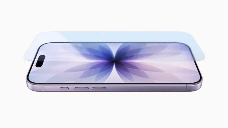 A smartphone with a purple flower design on its screen, featuring durable Apple Corning glass, lies flat with a transparent screen protector aligned above it. The phone is viewed from an angled side perspective on a white background.