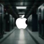 A large white Apple logo is centered over a blurred background of a server room, hinting at rising AI server demand, with rows of server racks and dim lighting. The Apple branding also appears in a small icon at the lower right corner.