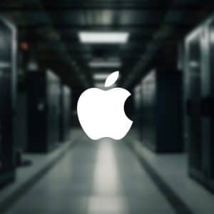 A large white Apple logo is centered over a blurred background of a server room, hinting at rising AI server demand, with rows of server racks and dim lighting. The Apple branding also appears in a small icon at the lower right corner.