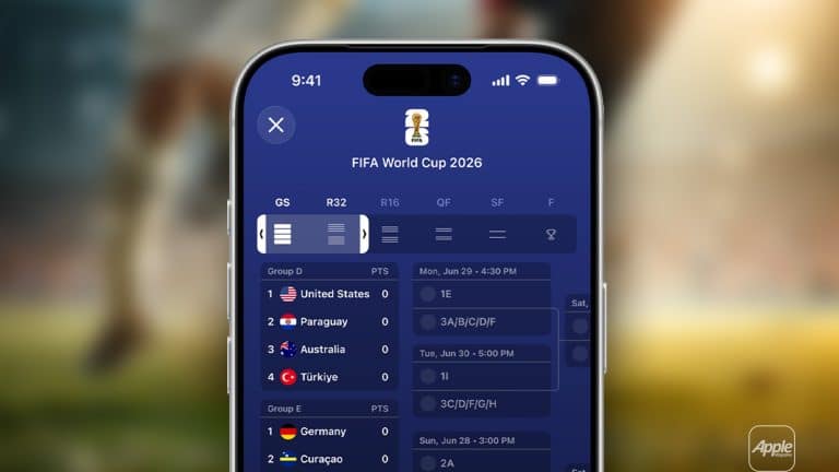 Close-up of a smartphone using Live Activities in the Apple Sports app to display the FIFA World Cup 2026 schedule, highlighting group stage matches for the United States, Paraguay, Australia, and Turkey. A blurred soccer field and players fill the background.