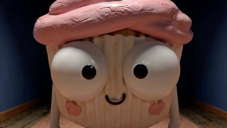 A cartoon cupcake with big googly eyes, a pink frosted top, blushing cheeks, and a small smile stands upright on a wooden floor inside a dimly lit room, as if ready to star in one of those quirky Prime Video AI shows.