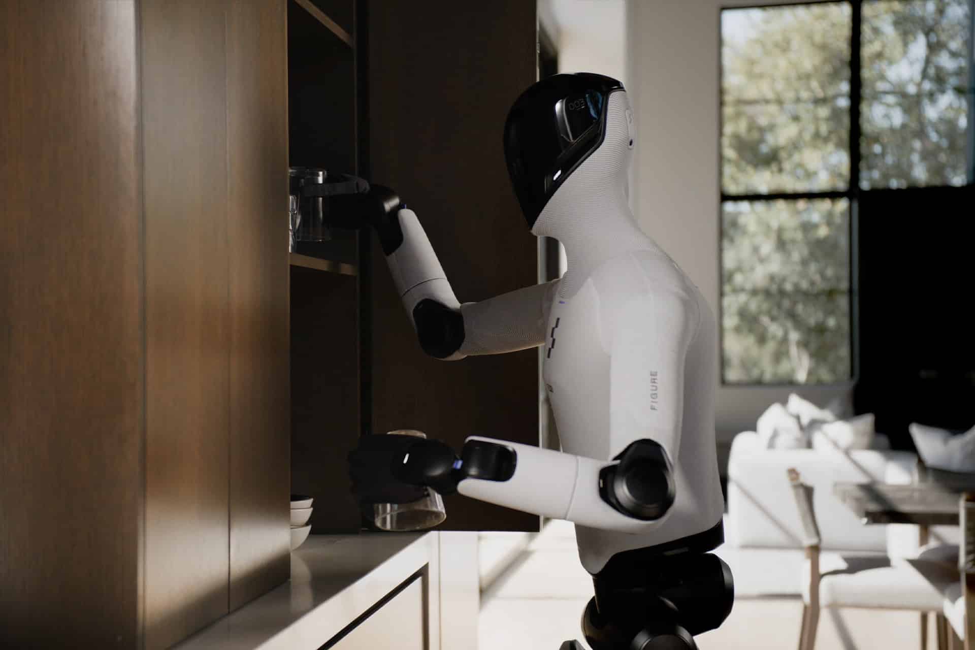 A humanoid robot featuring sleek white and black design, powered by advanced physical AI, reaches into a wooden kitchen cabinet for a glass in a modern, sunlit room with a sofa and large windows.