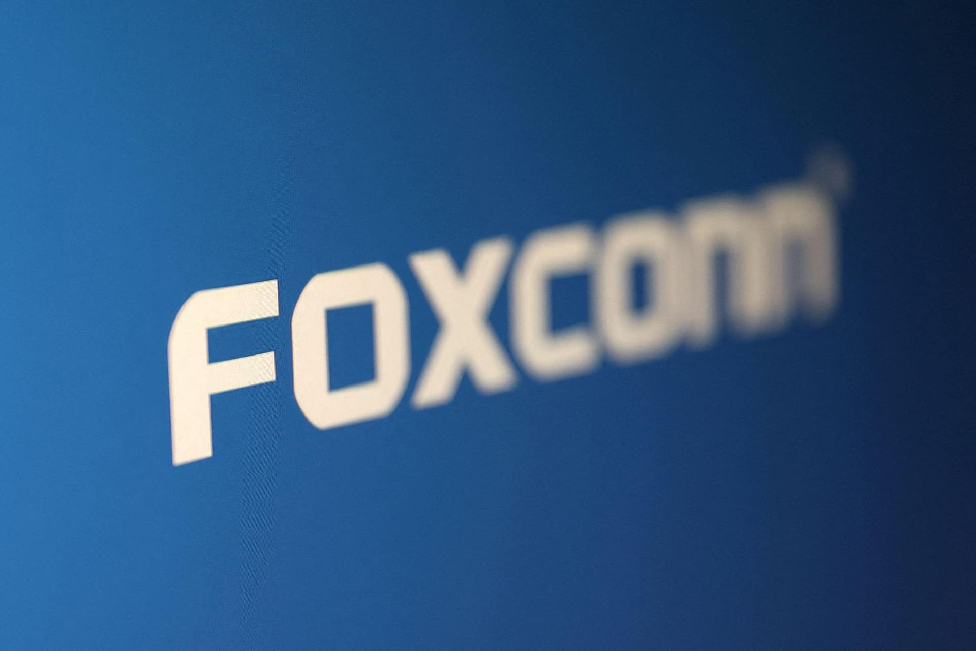 White text reading "FOXCONN" on a blue background, featuring a bold, modern font with slightly blurred edges—an eye-catching design reminiscent of headlines surrounding the recent Foxconn cyberattack.