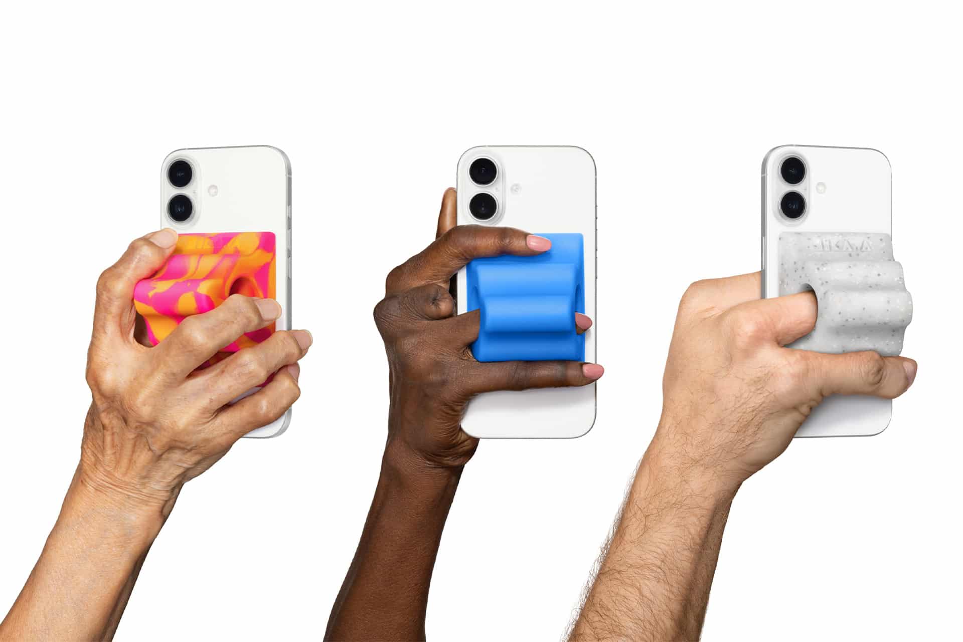 Three hands of different skin tones each hold a white smartphone with a colorful, textured grip—pink and orange, blue, and gray—against a white background, highlighting Apple accessibility and inclusivity in device design.