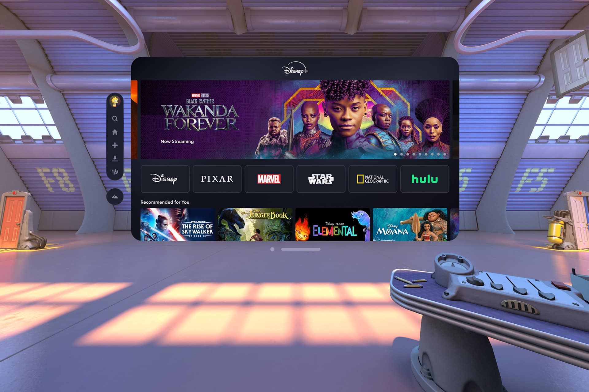 A virtual reality room with a large floating Disney+ screen displaying "Black Panther: Wakanda Forever" and streaming options for Disney, Pixar, Marvel, Star Wars, National Geographic, and Hulu—showcasing immersive Vision Pro content. A control console is in the foreground.