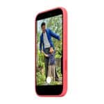 A pink smartphone with a MagSafe case displays a photo of an adult and child smiling together outdoors in a garden, surrounded by greenery, as the adult holds the child’s hands.