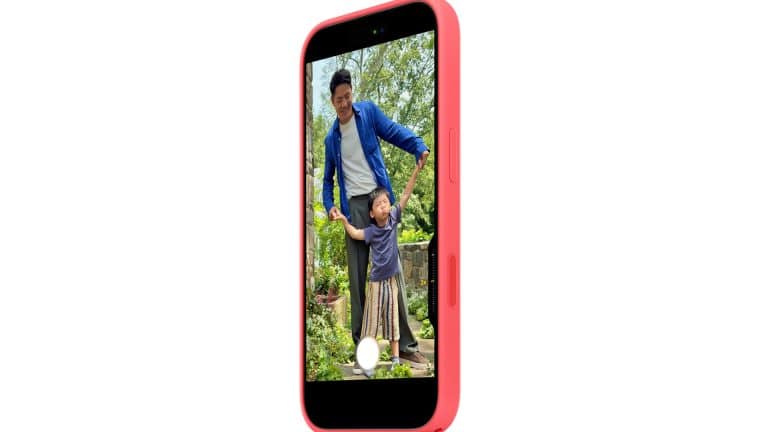 A pink smartphone with a MagSafe case displays a photo of an adult and child smiling together outdoors in a garden, surrounded by greenery, as the adult holds the child’s hands.