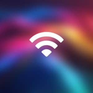 A white Mac Wi-Fi symbol is centered on a colorful, blurred gradient background with shades of pink, purple, blue, and yellow. The word "Apple" is in the bottom right corner.