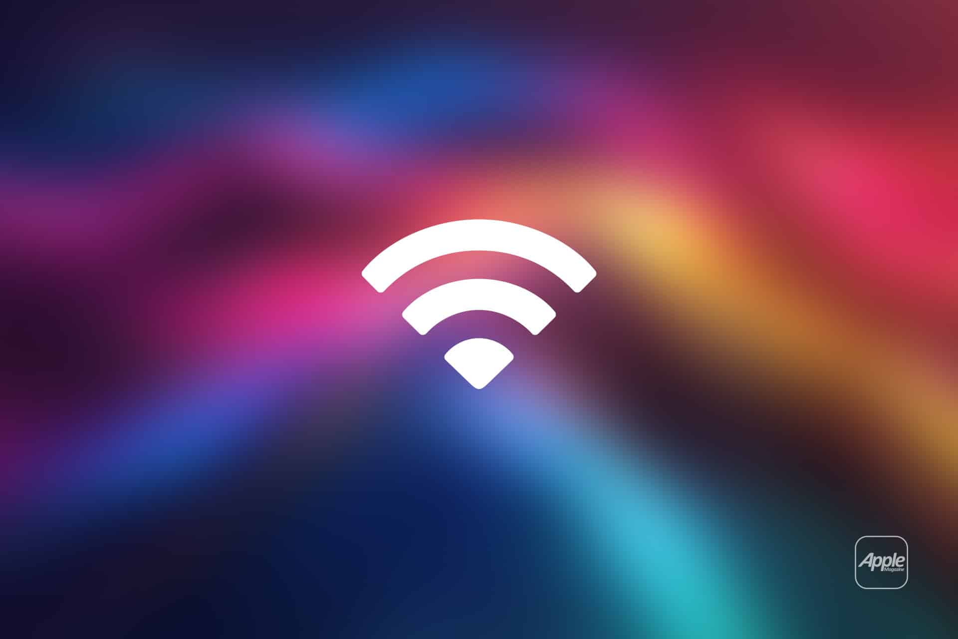 A white Mac Wi-Fi symbol is centered on a colorful, blurred gradient background with shades of pink, purple, blue, and yellow. The word "Apple" is in the bottom right corner.