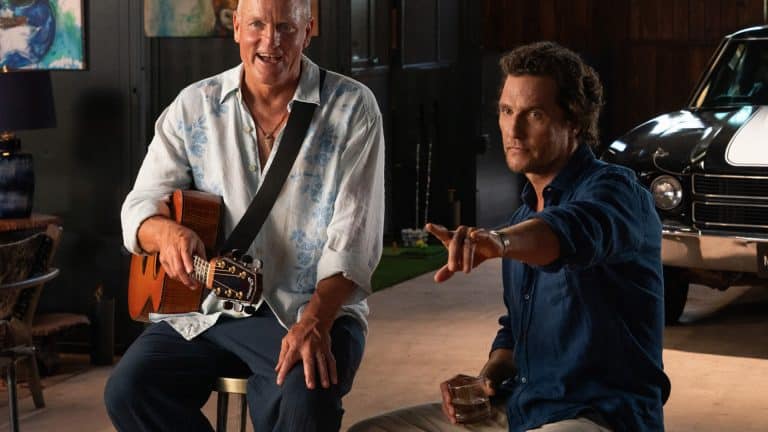 Brothers - Two brothers sit indoors; one, resembling Matthew McConaughey in a light floral shirt, smiles with a guitar, while the other gestures with his drink. A classic car peeks from the background—an Apple Originals vibe.