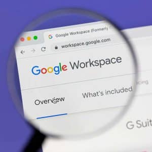 A magnifying glass focuses on the Google Workspace website in a web browser, highlighting the words “Overview” and “What’s included,” as Google Docs features are explored on a Mac.