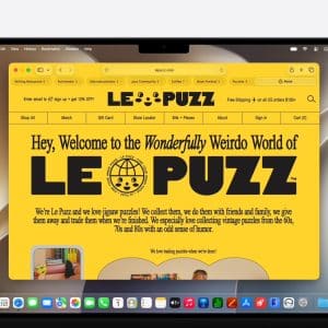 A laptop screen displays the LE PUZZ website in Safari tabs, featuring a bright yellow background, bold black text, and a circular logo. The site welcomes visitors to the “Wonderfully Weirdo World of LE PUZZ,” a jigsaw puzzle retailer.