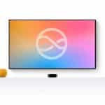 A flat-screen TV with a colorful gradient display and an abstract infinity symbol is mounted on a white wall. Below, a white shelf holds a small yellow sphere and the sleek Next-Gen Apple TV device.