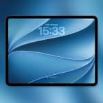 A tablet with a blue abstract iPad wallpaper displays a time of 15:33 and shows 100% battery charged. The background is a blue gradient, and an Apple logo is visible in the bottom right corner.