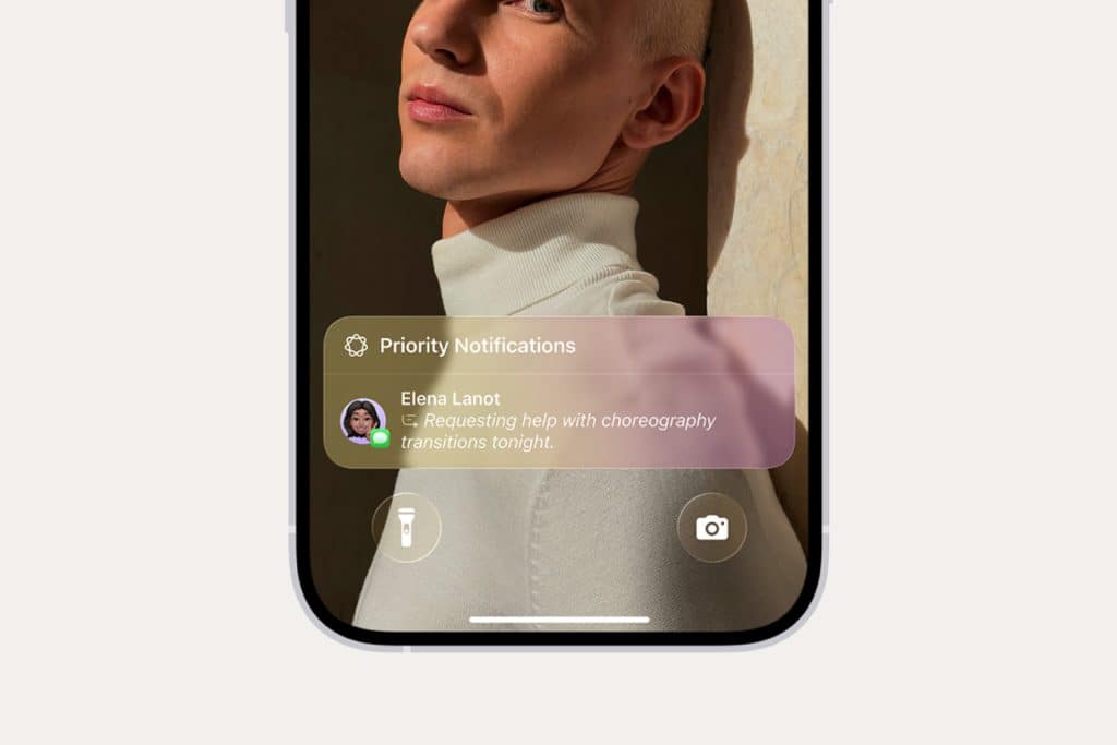 An iPhone Focus notification overlay appears on a smartphone screen, displaying a message from Elena Lanot: "Requesting help with choreography transitions tonight." The background shows a person in a white turtleneck.