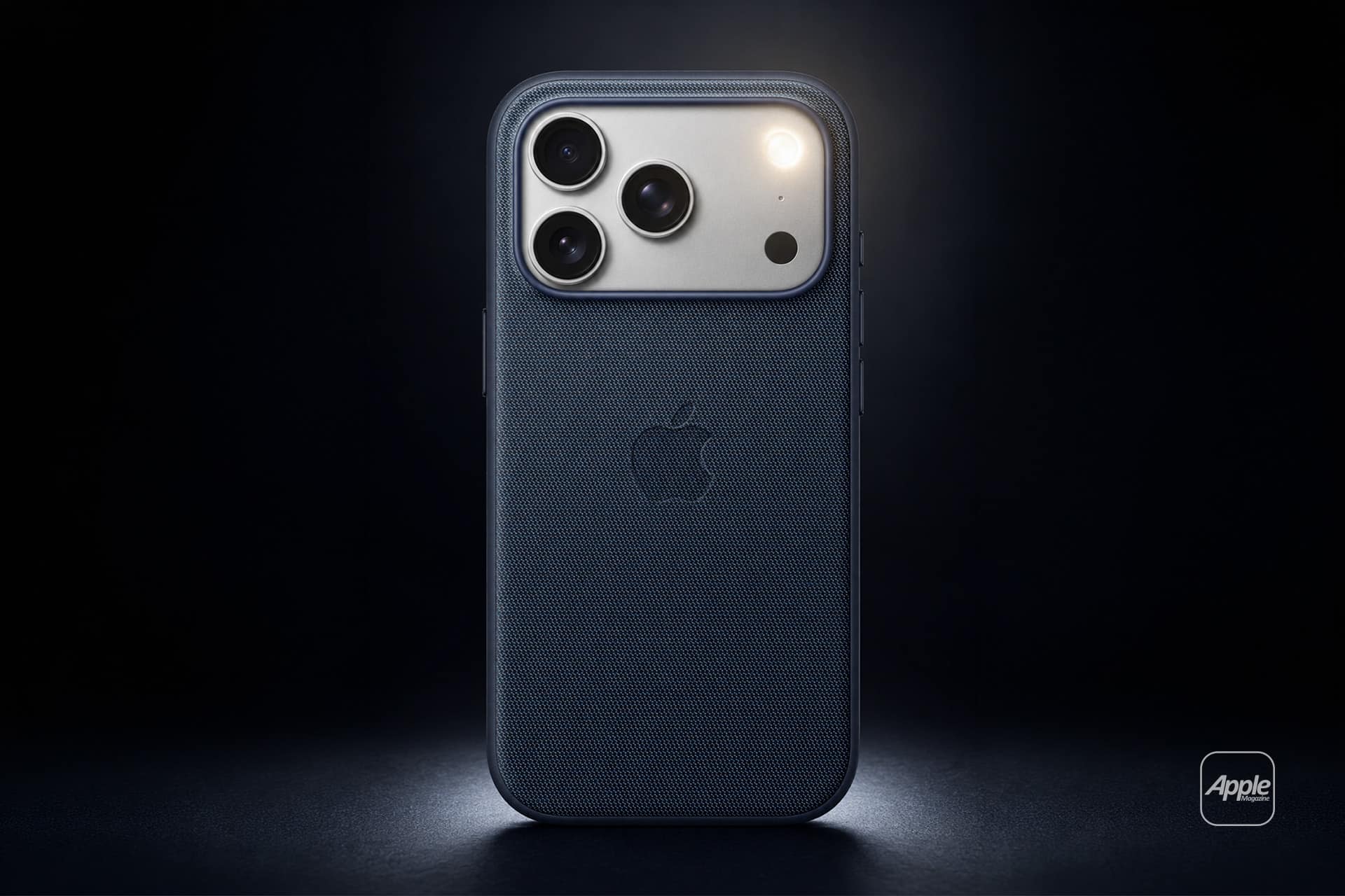A dark blue Apple iPhone with three camera lenses and a textured case is shown upright against a dark background, spotlight illuminating the upper part. The Apple logo is visible, highlighting its LED flash alerts for iPhone calls.
