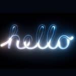 The word "hello" is written in a glowing, cursive neon light style on a dark background, with gradations of white, blue, and subtle yellow highlights illuminating the text—evoking the sleek, Liquid Glass aesthetic seen at WWDC26.