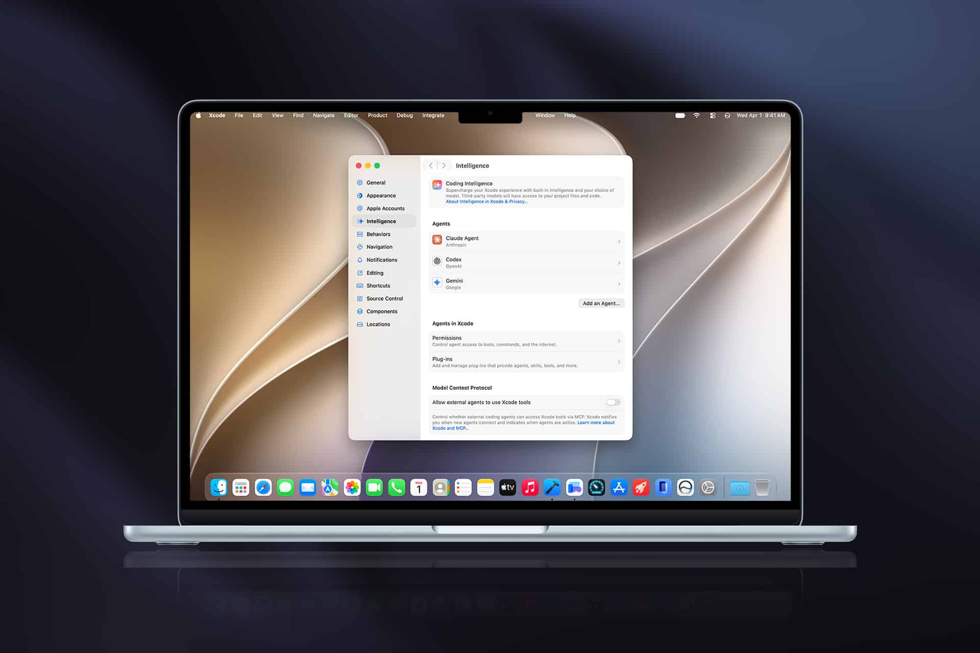 A MacBook displaying the System Settings window on the desktop, showing online account options. Xcode 27 app icons are visible in the dock at the bottom, and a beige abstract wallpaper is set as the background.