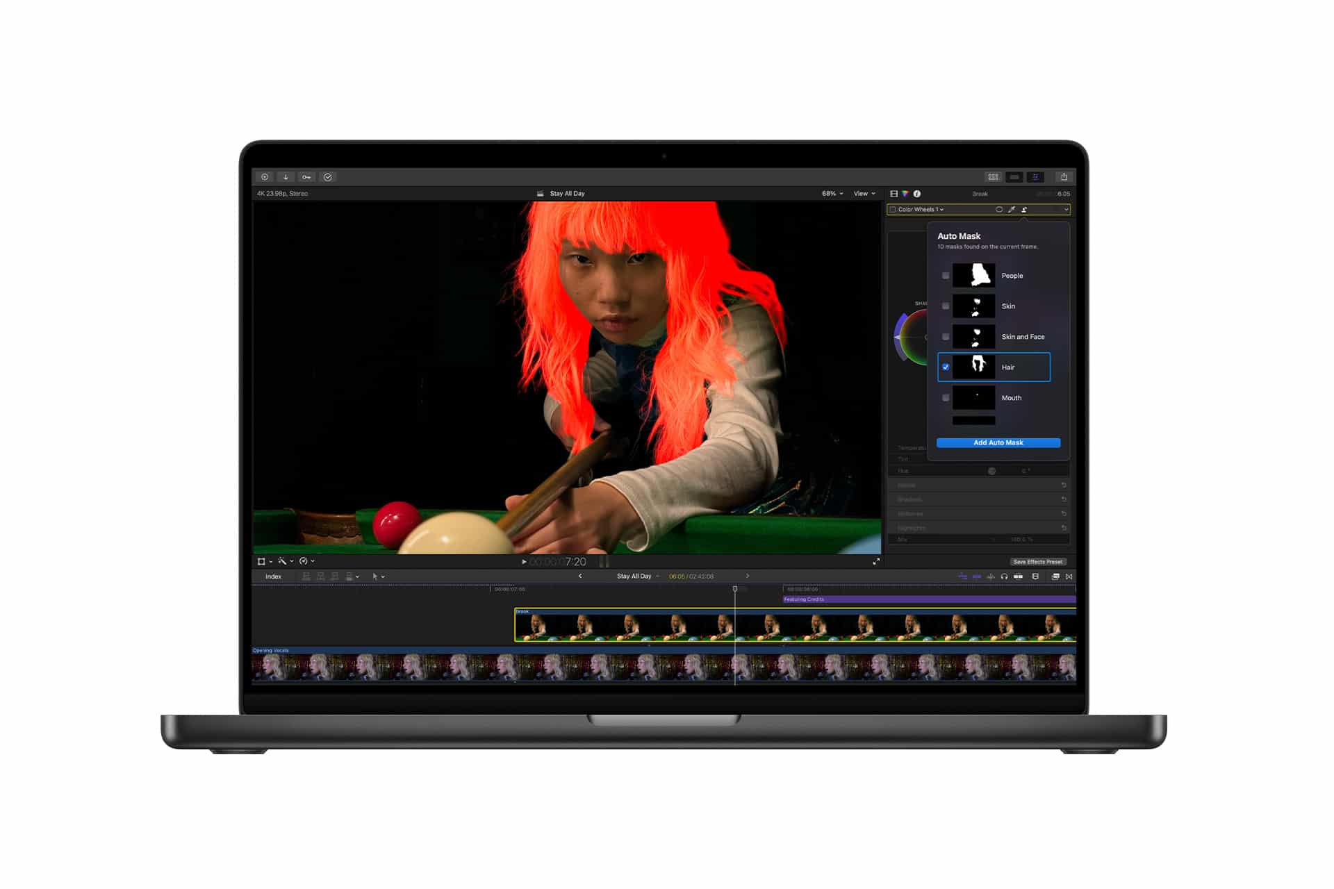 A laptop screen displays video editing software with a frame of a person playing pool; Pixelmator Pro’s mask tool highlights the person's hair in bright red. Editing options and controls are visible on the right side of the screen.