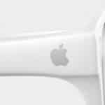 Close-up of the arm of a white pair of Apple Glasses featuring the silver Apple logo against a plain, light background.
