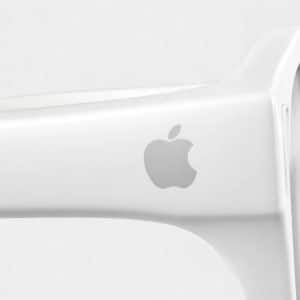 Close-up of the arm of a white pair of Apple Glasses featuring the silver Apple logo against a plain, light background.