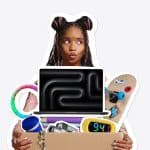 A person with space buns holds a box filled with various items, including a laptop, skateboard, clock, camera, and colorful toys, on a plain light background—capturing the excitement of Back to School season and the rush to catch Apple student deals before the Apple Back to School deadline.