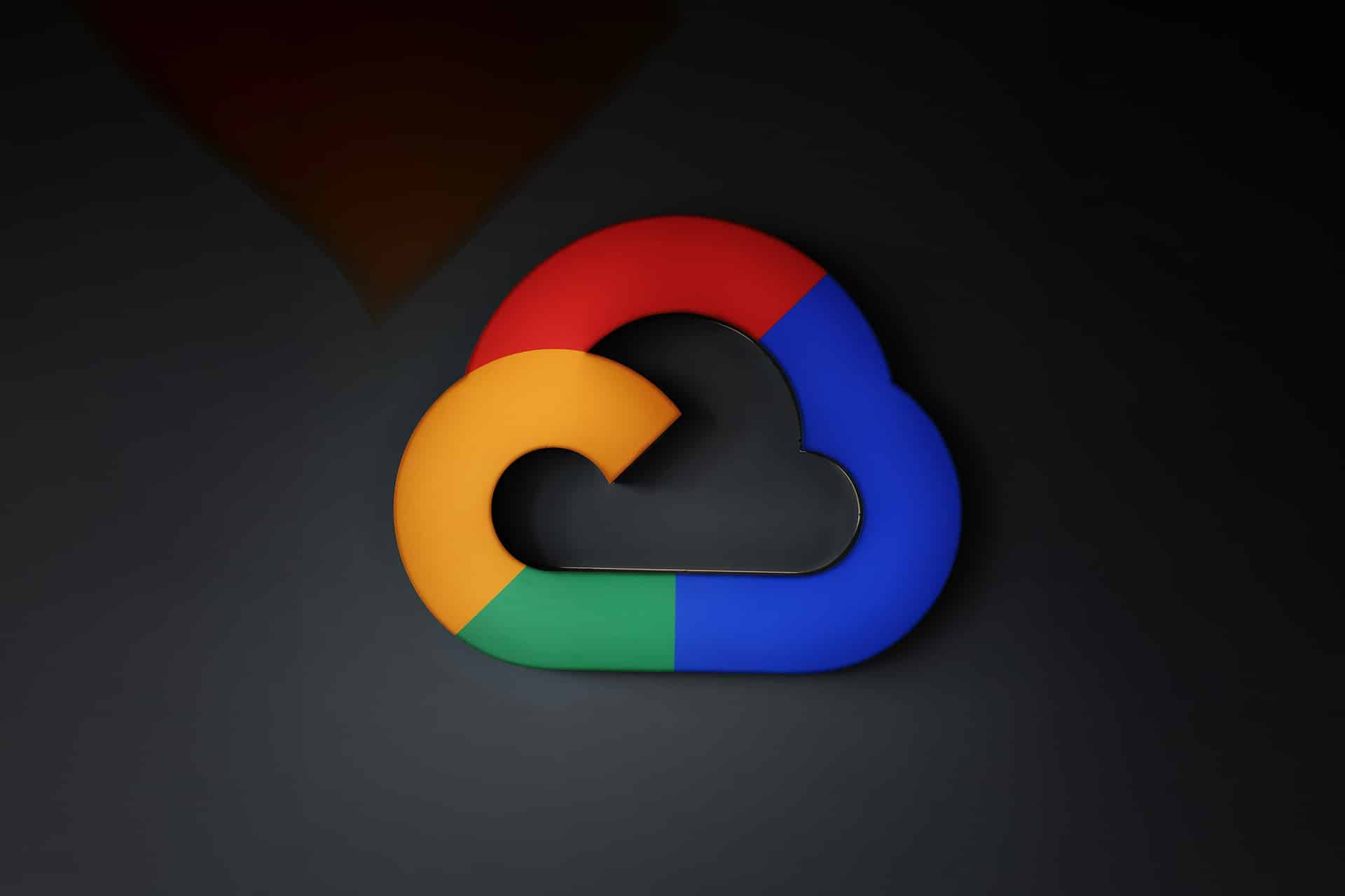 A stylized cloud logo in Google’s signature colors—red, yellow, green, and blue—set against a dark background, symbolizing Google Cloud services and seamless integration with iOS AI features.