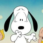 Snoopy looks surprised with one paw up, while Sally and Charlie Brown stand on either side, both appearing shocked. Set against a blue sky with simple clouds, this scene perfectly captures the whimsical charm of a classic Peanuts special as seen in Snoopy Presents on Apple TV.