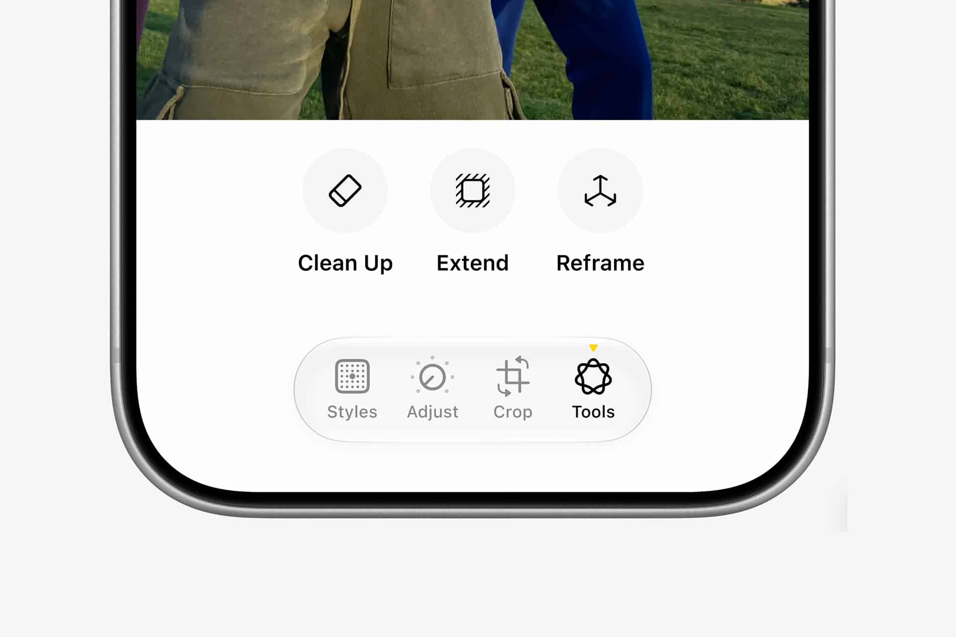 The bottom of a smartphone screen displays editing options: Clean Up, Extend, Reframe, and a highlighted Tools menu with icons for Styles, Adjust, Crop, and Tools. Part of a photo is visible above—inviting users to explore creative photo editing techniques like Spatial Reframing as they enhance their spatial memories through every adjustment.