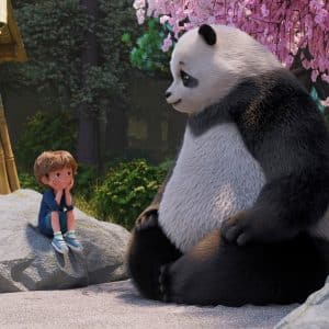 A young child sits on a rock, facing a large panda under pink cherry blossoms. Both appear relaxed, surrounded by trees and a bamboo structure in the background—a tranquil moment inspired by the animated series Stillwater, capturing the gentle wisdom and calm of Stillwater season 5.