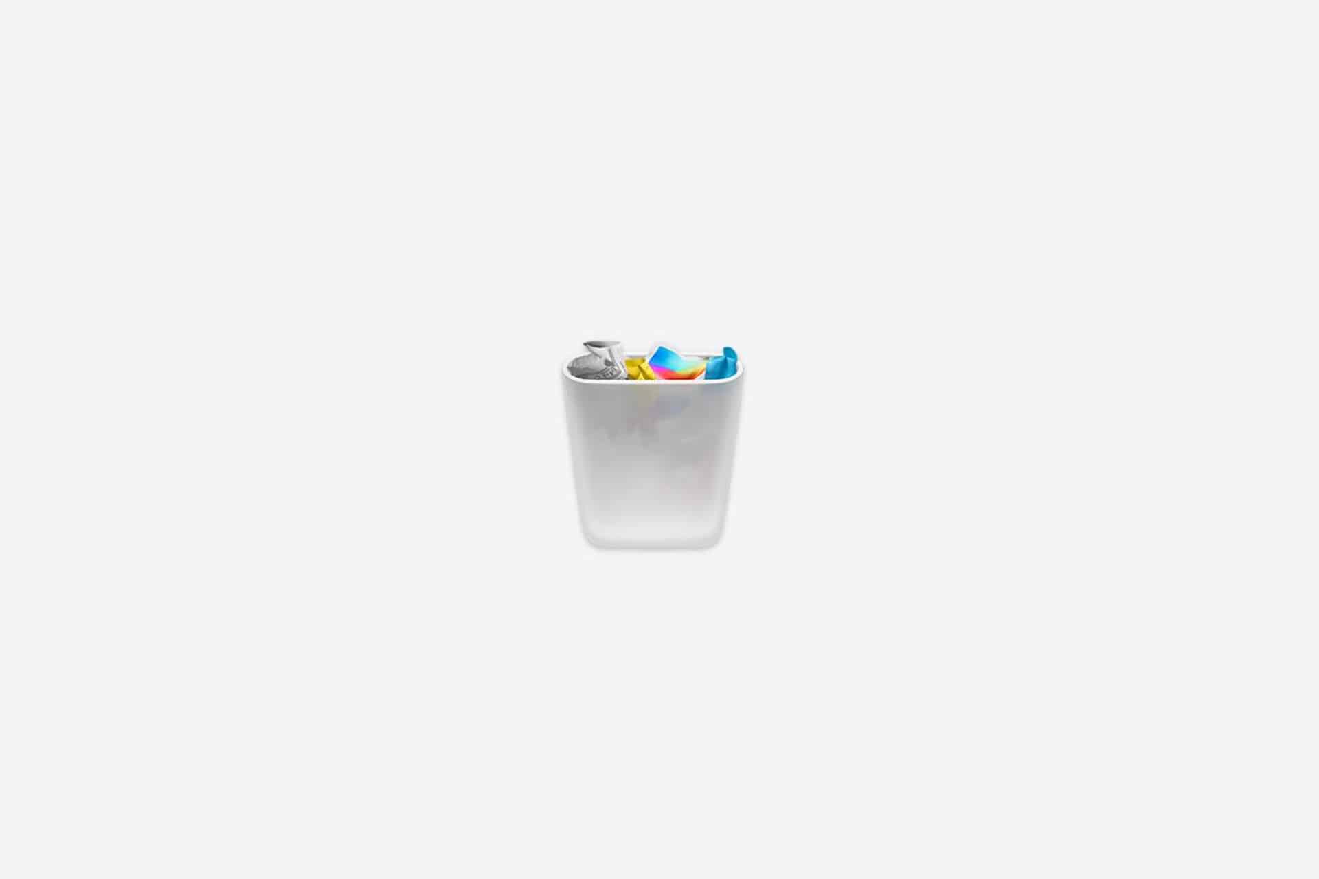 A silver trash bin filled with various colorful garbage items is centered on a plain, light gray background, symbolizing the process to uninstall Mac apps as part of regular Mac maintenance.
