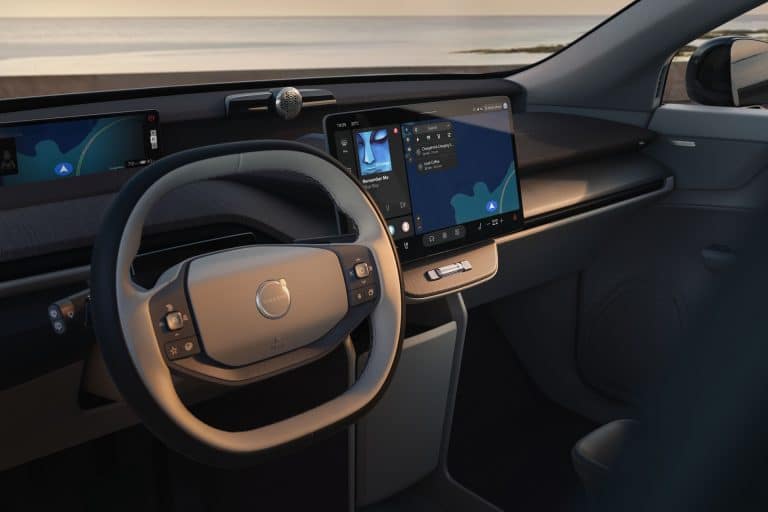 Interior of a Volvo vehicle featuring Apple Music on the central touchscreen alongside integrated navigation and vehicle controls.