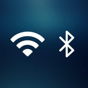 White Wi-Fi and Bluetooth icons on a dark blue gradient background, with a small Apple logo in the bottom right corner—an elegant nod to Apple’s Ecosystem, seamlessly connecting your devices through Wi-Fi and Bluetooth for effortless AirPlay experiences.