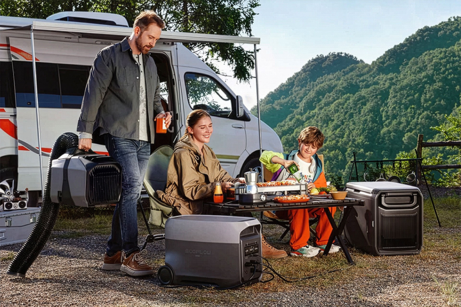 A man, woman, and child enjoy an outdoor meal at a campsite beside a camper van, surrounded by solar generators and mountains in the background, while their iPhone stays charged for capturing memories.