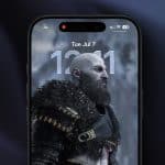 A smartphone screen displays the iPhone lock screen with a digital clock and date, featuring a bearded, armored warrior character as the wallpaper. The depth effect highlights the hero, while network and battery icons appear at the top.